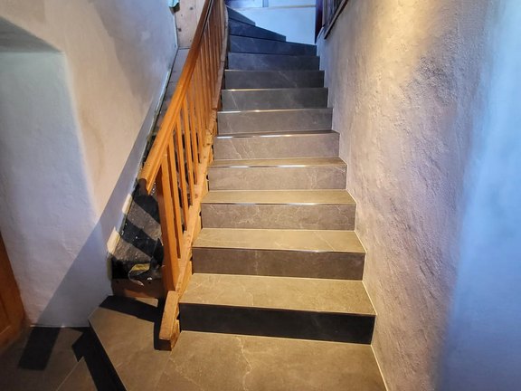 Fertige Treppe mit aus keramischen Grossformatplatten 120-60cm zugeschnitten, damit ganze Trittflächen möglich