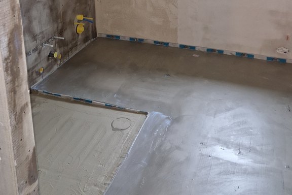 Elektrische Fussbodentemperierung im ganzen Nassraum und Duschboden damit das Kältegefühl mit keramischen Bodenplatten ausgeschlossen ist